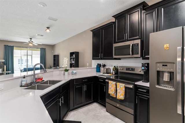 1079 Quaker Ridge Ln, Davenport, FL 33896 - kitchen featuring dark cabinetry, appliances with stainless steel finishes, light countertops, and a sink