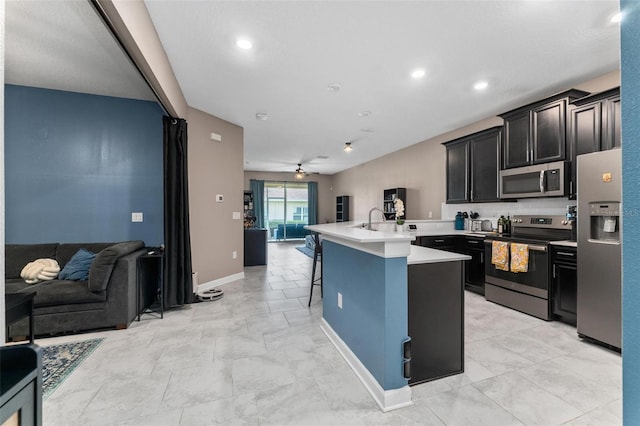 1079 Quaker Ridge Ln, Davenport, FL 33896 - kitchen featuring a breakfast bar, open floor plan, appliances with stainless steel finishes, and light countertops