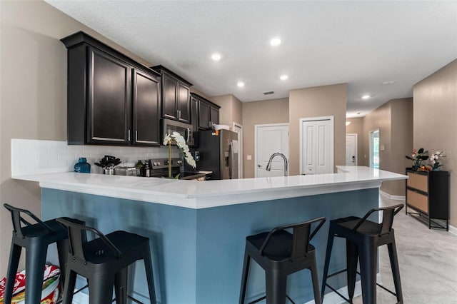 1079 Quaker Ridge Ln, Davenport, FL 33896 - kitchen with recessed lighting, stainless steel appliances, a kitchen breakfast bar, backsplash, and light countertops