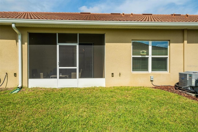 1079 Quaker Ridge Ln, Davenport, FL 33896 - back of property with stucco siding, cooling unit, a yard, and a sunroom