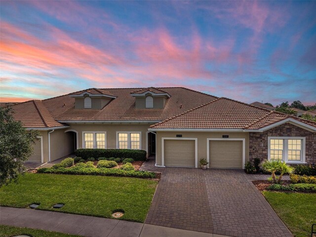 1079 Quaker Ridge Ln, Davenport, FL 33896 - mediterranean / spanish-style home with a front lawn, a garage, stucco siding, and a tiled roof