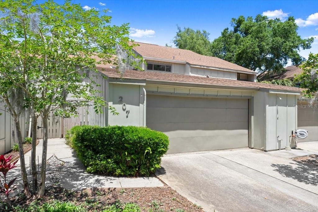 garage featuring fence and concrete driveway