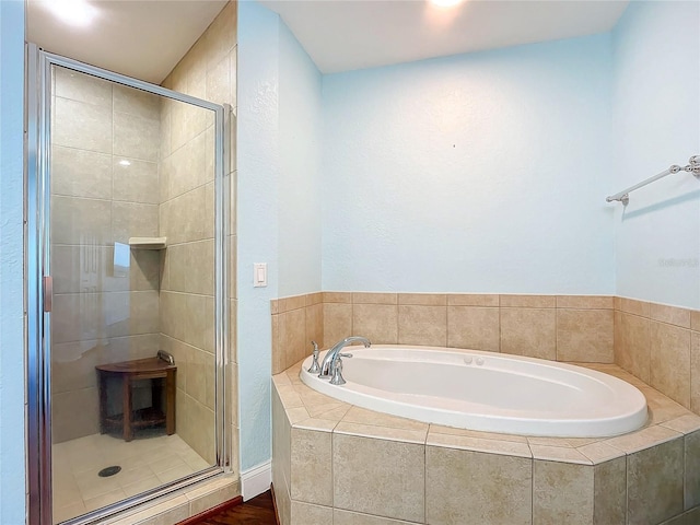 bathroom with a shower stall and a garden tub