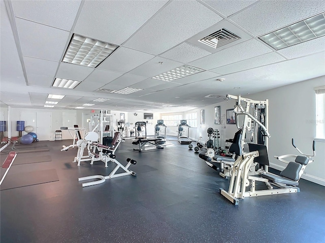 exercise room featuring baseboards, visible vents, and a drop ceiling