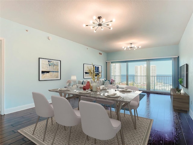 2 Oceans W Blvd Unit 1007, Daytona Beach, FL 32118 - dining space with a chandelier, hardwood / wood-style floors, baseboards, and a textured ceiling