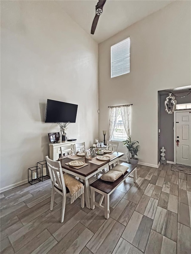 103 Manor View Ln, Deland, FL 32724 - dining room featuring high vaulted ceiling, baseboards, a ceiling fan, and wood finished floors