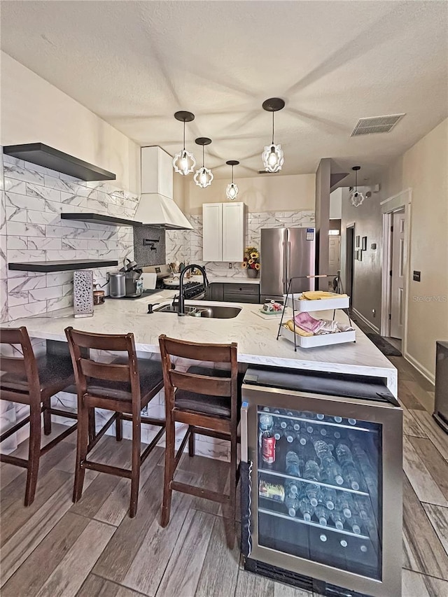 103 Manor View Ln, Deland, FL 32724 - kitchen featuring tasteful backsplash, wood finished floors, a sink, freestanding refrigerator, and white cabinetry