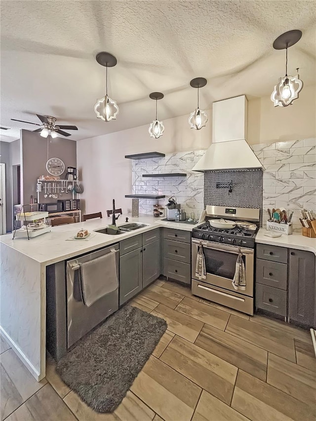 103 Manor View Ln, Deland, FL 32724 - kitchen featuring a peninsula, custom exhaust hood, a sink, appliances with stainless steel finishes, and gray cabinetry