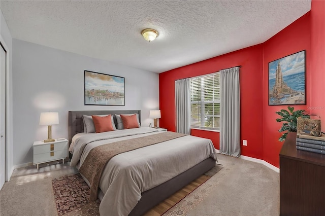 carpeted bedroom with a textured ceiling and baseboards