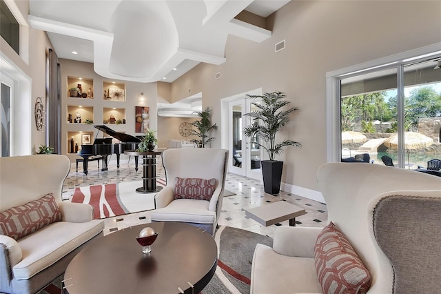 living area with a towering ceiling, baseboards, and beamed ceiling