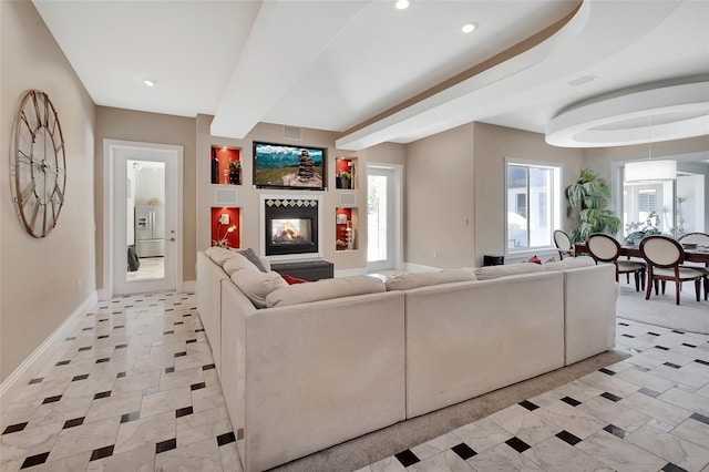 living area with baseboards, a multi sided fireplace, and recessed lighting