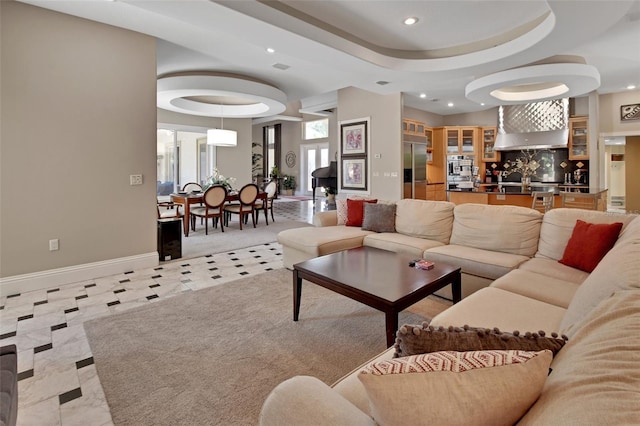 living room with recessed lighting, baseboards, and a tray ceiling