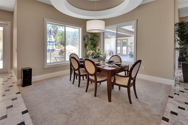 dining space with baseboards and light carpet