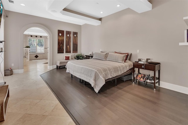 bedroom featuring baseboards, arched walkways, and recessed lighting