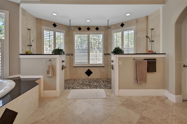 full bathroom featuring plenty of natural light, a walk in shower, recessed lighting, baseboards, and a bath