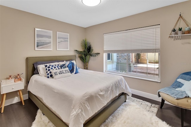 bedroom with baseboards and wood finished floors