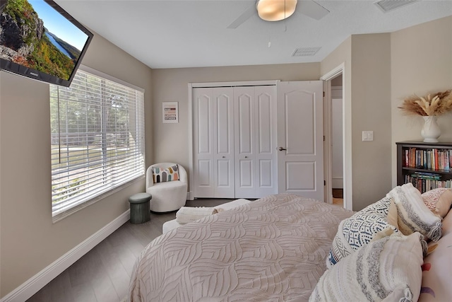 bedroom featuring baseboards, wood finished floors, a closet, and a ceiling fan