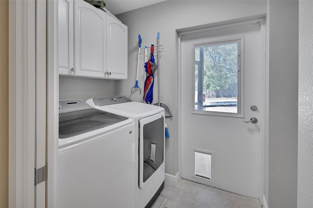 washroom featuring washer and dryer, cabinet space, baseboards, and light tile patterned floors
