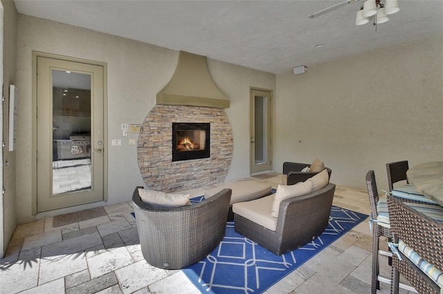 view of patio with an outdoor stone fireplace and ceiling fan