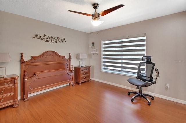 bedroom with light wood-type flooring, baseboards, and ceiling fan