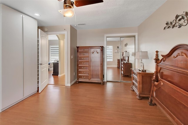 bedroom featuring wood finished floors, baseboards, recessed lighting, a ceiling fan, and arched walkways