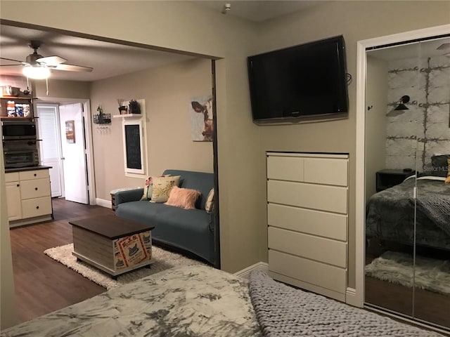 living area with ceiling fan, dark wood-type flooring, and baseboards