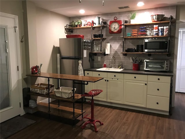 kitchen with a sink, stainless steel appliances, dark wood-style flooring, and open shelves
