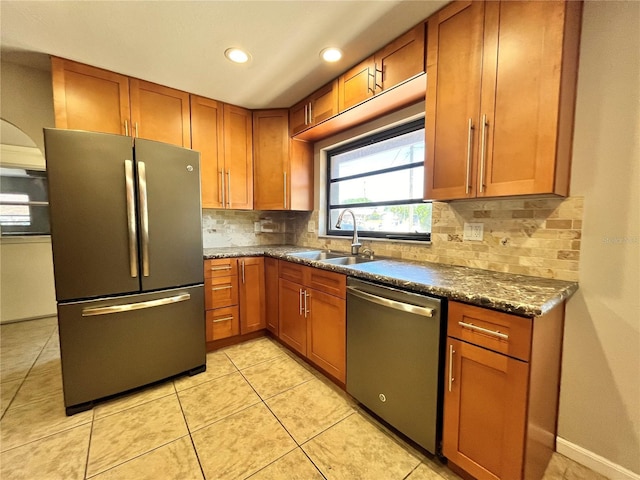 kitchen featuring brown cabinetry, stainless steel appliances, and a sink