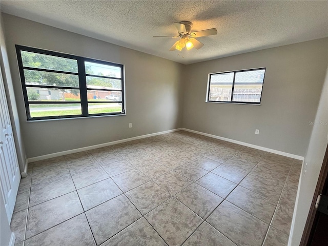 unfurnished room with light tile patterned floors, a textured ceiling, a ceiling fan, and baseboards