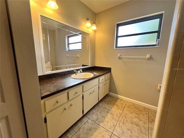 bathroom featuring vanity, tile patterned flooring, and baseboards