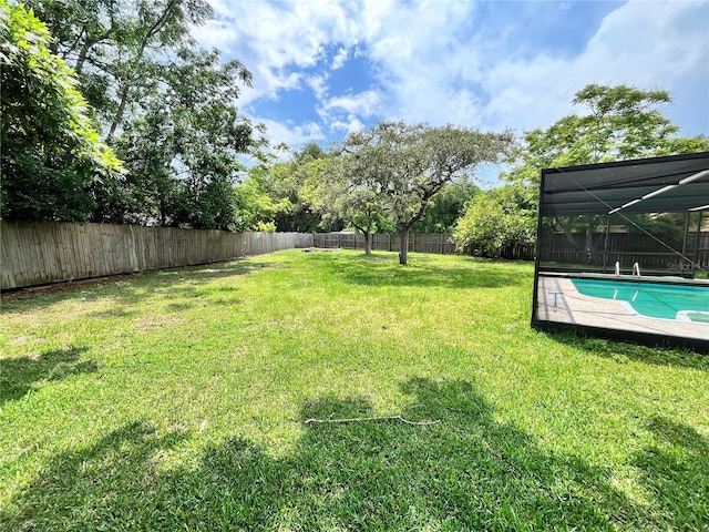 view of yard featuring a fenced in pool, a lanai, and a fenced backyard