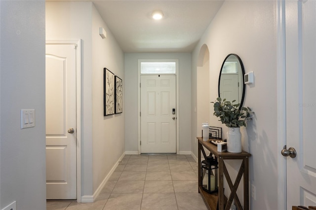 entryway with baseboards and light tile patterned floors