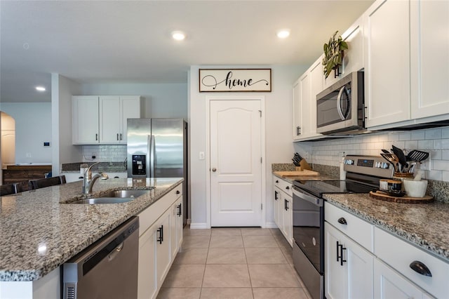 kitchen featuring backsplash, white cabinets, appliances with stainless steel finishes, and a sink