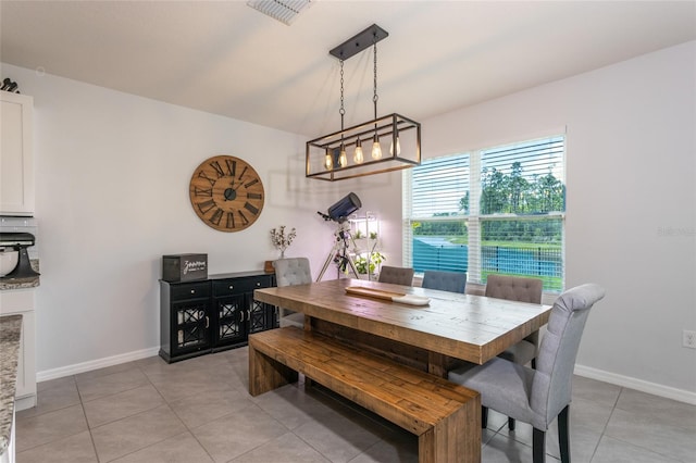 dining space featuring baseboards, light tile patterned flooring, and visible vents