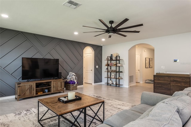 living room featuring arched walkways, baseboards, visible vents, recessed lighting, and a ceiling fan