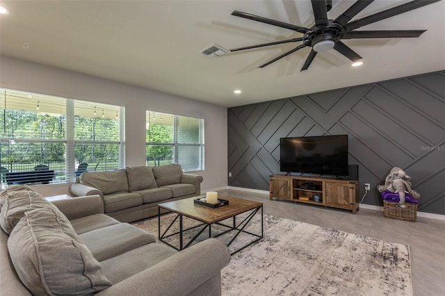 living room featuring recessed lighting, visible vents, an accent wall, a decorative wall, and baseboards