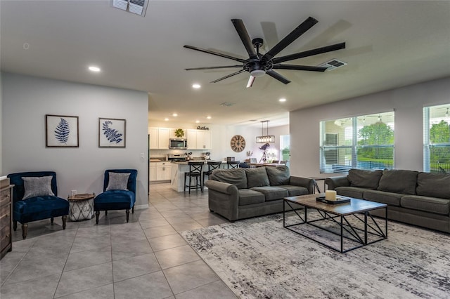 living room featuring a ceiling fan, light tile patterned flooring, visible vents, and recessed lighting