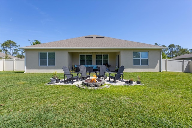 rear view of house featuring stucco siding, an outdoor fire pit, and fence private yard