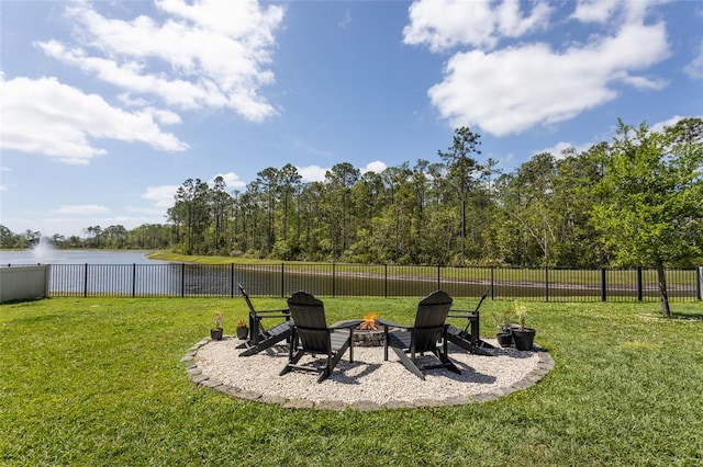 view of yard featuring a fire pit, fence, and a water view