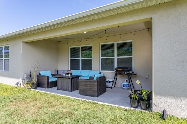 rear view of house with an outdoor hangout area, a patio, and stucco siding