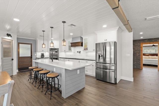 kitchen featuring recessed lighting, custom exhaust hood, white cabinetry, baseboards, and appliances with stainless steel finishes
