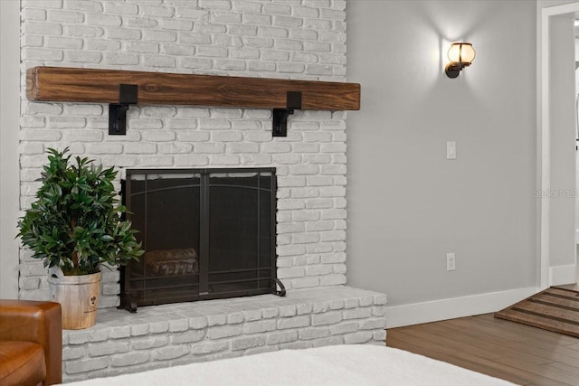 room details with wood finished floors, baseboards, and a fireplace