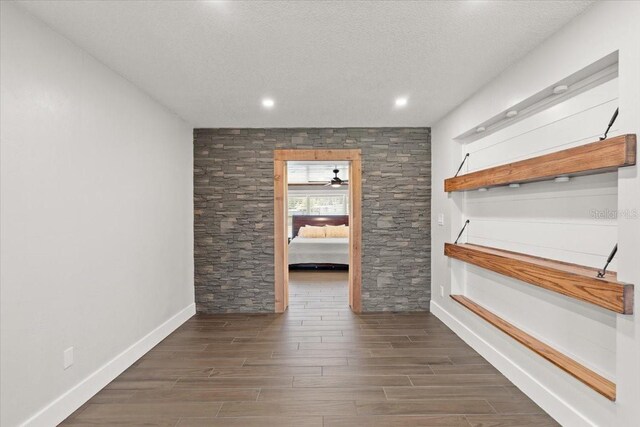 interior space featuring wood finished floors, a ceiling fan, a textured ceiling, baseboards, and recessed lighting