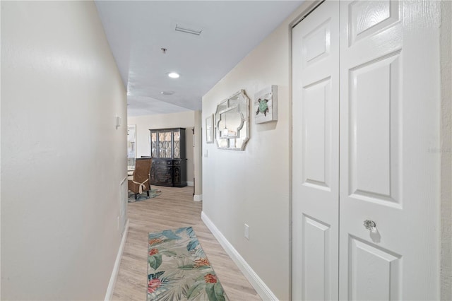 hall with light wood-style floors, baseboards, recessed lighting, and visible vents