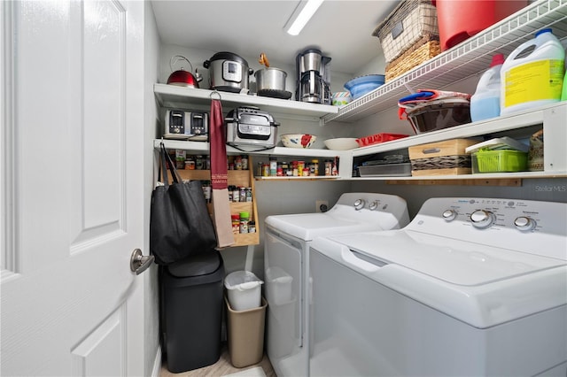 clothes washing area featuring separate washer and dryer and laundry area