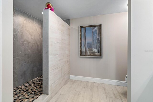 full bath with baseboards, walk in shower, and toilet