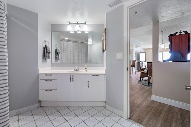 bathroom featuring baseboards, tile patterned flooring, vanity, and visible vents