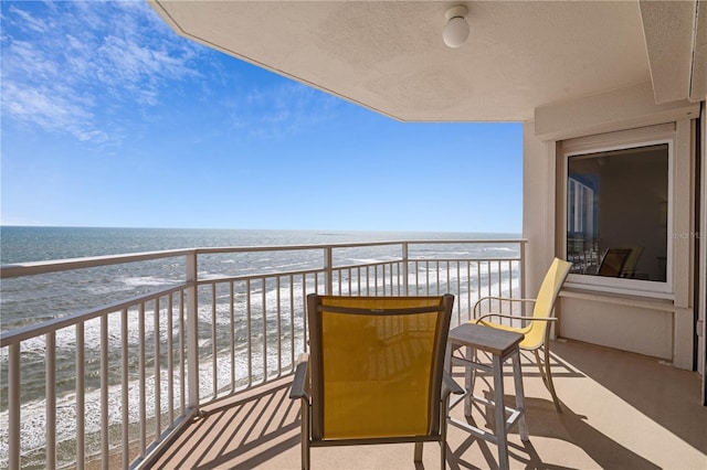 balcony with a water view and a beach view