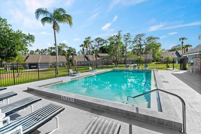 pool with a residential view, a yard, a patio area, and fence