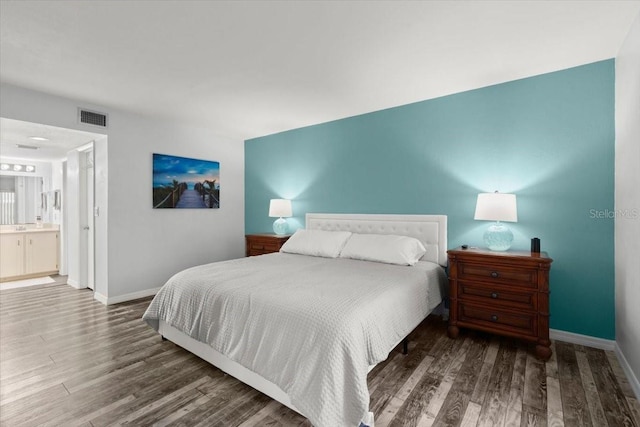 bedroom featuring wood finished floors, visible vents, and baseboards